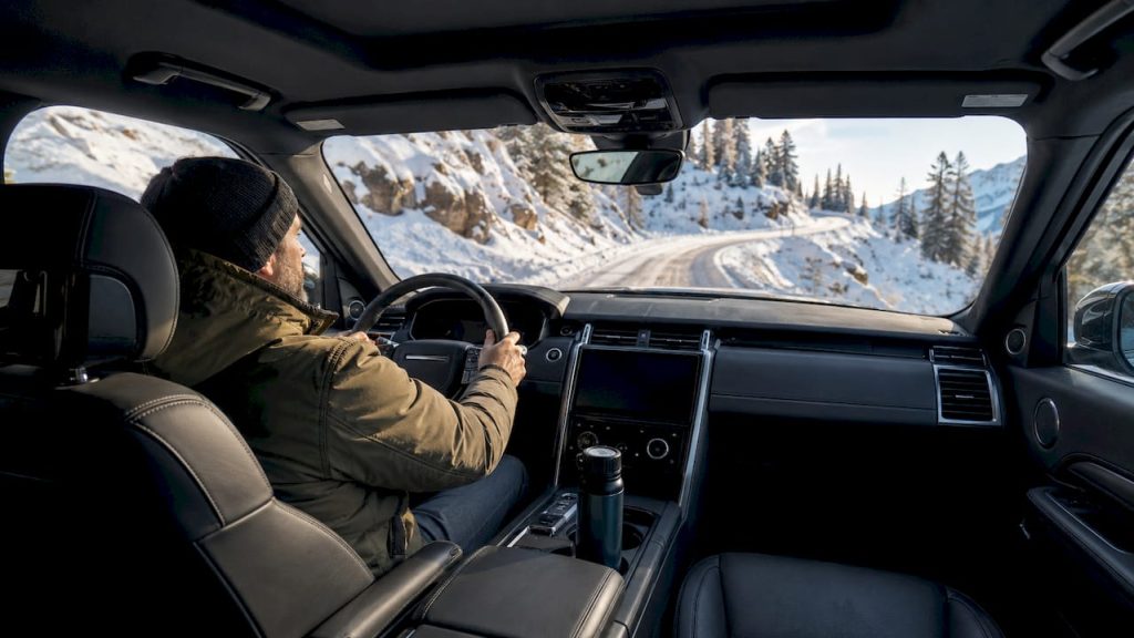 Au volant d’un véhicule tout confort, je traverse des paysages de montagne recouverts de neige.